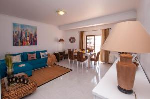 a living room with a blue couch and a table at Waves by OCvillas in Albufeira
