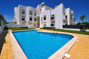 a villa with a swimming pool in front of a building at Waves by OCvillas in Albufeira