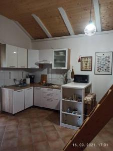 a large kitchen with white cabinets and a staircase at Rare find! Dogs Welcome Secluded Comfy House Krk in Šilo