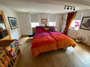 um quarto com uma cama grande e um edredão colorido em Wohnen & Kunst em Bad Rodach