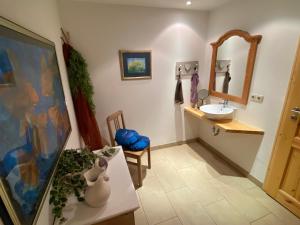 uma casa de banho com um lavatório, um espelho e um lavatório. em Wohnen & Kunst em Bad Rodach
