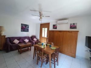 een woonkamer met een tafel en een bank bij Gîte Rosa et Jean-Jacques in Aigues-Mortes