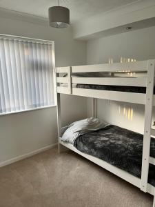 a bedroom with two bunk beds and a window at Seaside Haven in Hunstanton