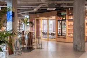 a restaurant with stools and a bar in a building at ibis budget Gent Centrum Dampoort in Ghent