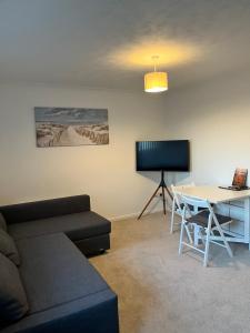 a living room with a couch and a table at Seaside Haven in Hunstanton