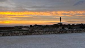 a stone wall with a sunset in the background at Locanda Gulfi in Chiaramonte Gulfi