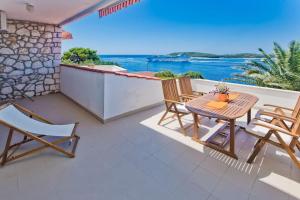 een patio met een tafel en stoelen en de oceaan bij Villa Porthos in Hvar