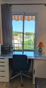 a desk with a chair in front of a window at La Ciotat, appartement rénové en bord de mer in La Ciotat