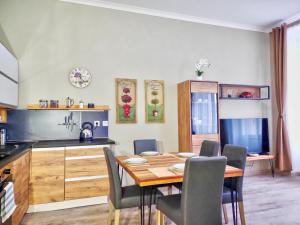 eine Küche mit einem Holztisch und Stühlen im Zimmer in der Unterkunft Carlsbad Family Apartment in Karlsbad