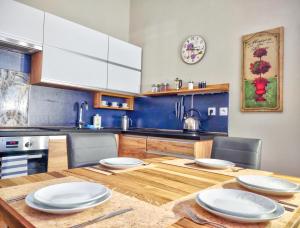 eine Küche mit einem Holztisch mit weißen Platten darauf in der Unterkunft Carlsbad Family Apartment in Karlsbad