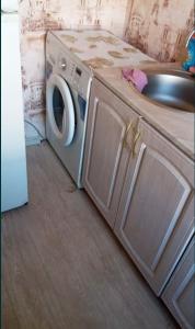 una cucina con lavatrice e lavandino di 1 комнатная квартира a Rudny