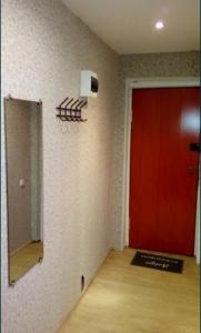 una stanza con una porta rossa e uno specchio di 1 комнатная квартира a Rudny