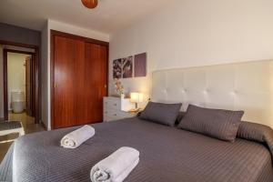 - une chambre avec un grand lit et des serviettes dans l'établissement Ideal Property Mallorca - Nice 4 You, à Port d'Alcúdia