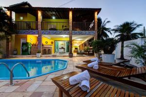 a resort with a swimming pool and a house at Casarão Serenitá in Aquiraz