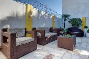 a patio with wicker chairs and a table at Casarão Serenitá in Aquiraz
