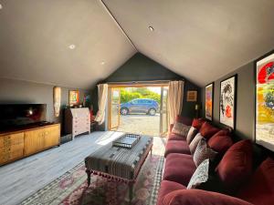 sala de estar con sofá y TV en Quirky Luxury Barn Sleeps 8, Pet Friendly en Calne