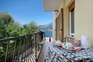 a table on a balcony with a view of the water at Appartamento Marilu Lake View in Brenzone sul Garda