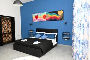 um quarto com uma cama preta e uma parede azul em B&B Carlo V - House Hotel em Capua