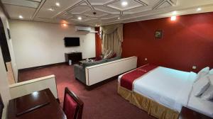 ハフル・アル・バティンにあるAl Mansour Grand Hotelのベッドとソファ付きのホテルルーム