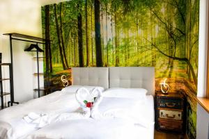 a bedroom with two beds with a forest mural on the wall at Guesthouse Rosengarten in Dobbiaco