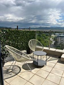 un paio di sedie e un tavolo sul balcone di ROOF TOP LUXURY a Blagoevgrad