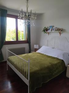 a bedroom with a bed and a chandelier at L'appartamento Italia B. in Treviso