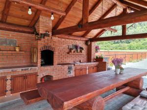 an outdoor kitchen with a wooden table and a brick oven at Dió vendégház in Praid