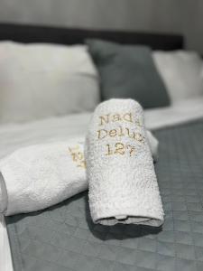 a towel with the words nada drink sitting on a bed at Apartman Nada de lux in Vrnjačka Banja +13 photos