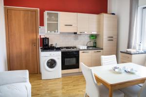 een keuken met een wasmachine en een tafel met stoelen bij B&B Pitagora in Crotone