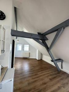 an attic room with a wooden floor and white walls at Strahlende Wohlfühloase in Marktheidenfeld