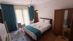 ウズンギョルにあるUzungol Soylu Hotelのベッドと椅子付きのホテルルーム