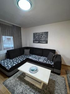 a living room with a couch and a table at Apartman Nada de lux in Vrnjačka Banja