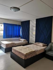 2 camas en una habitación con cortina azul en Popular Condo by Jintana en Pak Kret