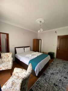 1 dormitorio con 1 cama grande y 2 sillas en Uzungol Soylu Hotel, en Uzungöl