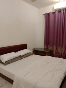 una camera con letto e tenda viola di Gallata Two Bedroom Street View a Port Dickson