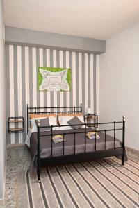 a bedroom with a bed and a striped wall at B&B Carlo V - House Hotel in Capua