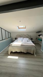 a bedroom with a large bed with a skylight at Chambre d hôte petit crussac in Mauvezin