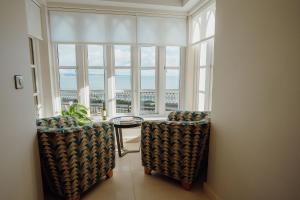 a room with a table and chairs and a large window at Ocean House, Tenby in Tenby