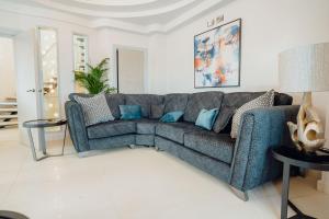 a living room with a blue couch in a room at Ocean House, Tenby in Tenby