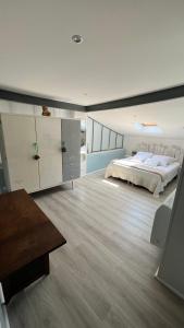 ein großes Schlafzimmer mit einem Bett und einem Holzboden in der Unterkunft Chambre d hôte petit crussac in Mauvezin