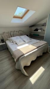 Schlafzimmer mit einem großen Bett und einem Dachfenster in der Unterkunft Chambre d hôte petit crussac in Mauvezin