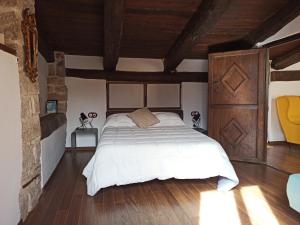 a bedroom with a large white bed and wooden ceilings at Casa El Inglés in Mora de Rubielos