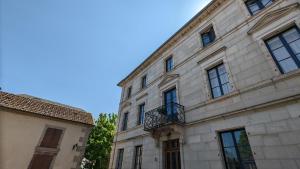 un gran edificio de piedra con ventanas y balcón en Manoir La Cerise, en Fougerolles