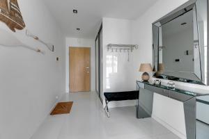 a white bathroom with a sink and a mirror at Grand Apartments - Apartament Tre Mare - By the sea in Gdańsk