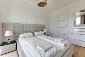 a white bedroom with two beds and a window at Grand Apartments - Apartament Tre Mare - By the sea in Gdańsk