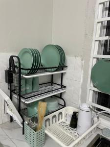 a kitchen with plates and dishes on a shelf at Ruwa Homestay Jitra - 3BR, EV Port in Jitra