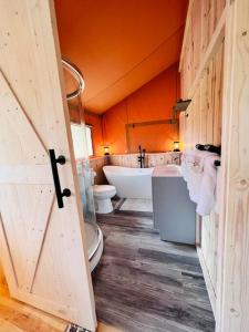 a bathroom with two toilets and a bath tub at Tropical glamping with hot tub in Cleveland