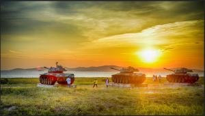 a group of tanks parked in a field with the sunset at 金門瑜仙-住宿租機車-接機免費 in Jinhu