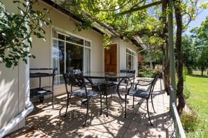 un patio con mesa y sillas. en Lowestoffe Country Lodge - Trout en Hogsback
