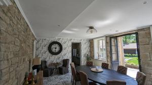 d'une salle à manger avec une table et un mur en pierre. dans l'établissement Manoir La Cerise, à Fougerolles